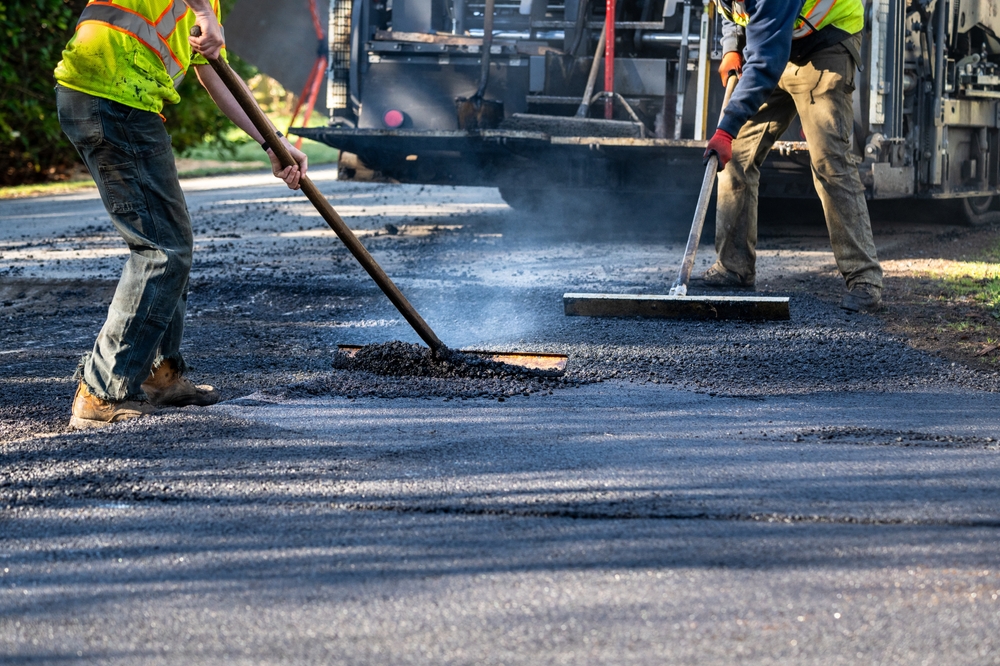 Residential,street,repaving,project,,workers,in,safety,clothes,smoothing,fresh